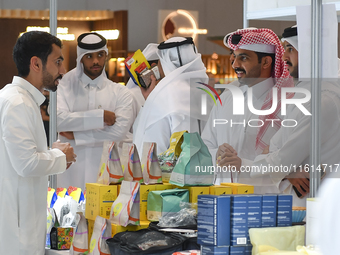 Visitors watch coffee products at a booth during the 2024 Doha International Coffee Exhibition at Doha Exhibition and Convention Center in D...