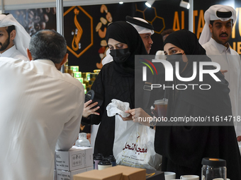 Visitors watch coffee products at a booth during the 2024 Doha International Coffee Exhibition at Doha Exhibition and Convention Center in D...