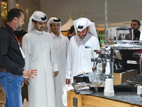 Visitors look at the coffee maker at a booth during the 2024 Doha International Coffee Exhibition at Doha Exhibition and Convention Center i...