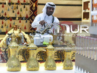 A Qatari man prepares traditional Qatari Arabic coffee during the 2024 Doha International Coffee Exhibition at Doha Exhibition and Conventio...