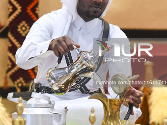 A Qatari man prepares traditional Qatari Arabic coffee during the 2024 Doha International Coffee Exhibition at Doha Exhibition and Conventio...