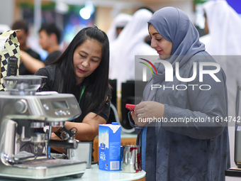 An exhibitor introduces products to a visitor at the 2024 Doha International Coffee Exhibition at Doha Exhibition and Convention Center in D...