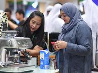 An exhibitor introduces products to a visitor at the 2024 Doha International Coffee Exhibition at Doha Exhibition and Convention Center in D...