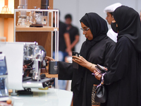 Visitors watch coffee products at a booth during the 2024 Doha International Coffee Exhibition at Doha Exhibition and Convention Center in D...