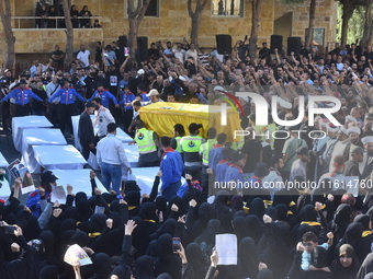 Lebanese clerics pray over the coffins of 16 people, including three Hezbollah militants, who are killed in an Israeli airstrike on the vill...