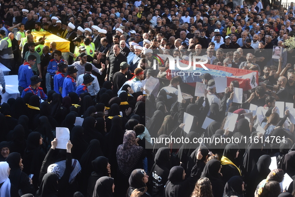 Lebanese clerics pray over the coffins of 16 people, including three Hezbollah militants, who are killed in an Israeli airstrike on the vill...