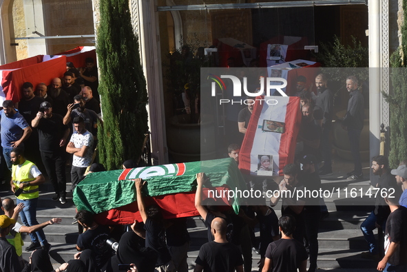 Lebanese clerics pray over the coffins of 16 people, including three Hezbollah militants, who are killed in an Israeli airstrike on the vill...