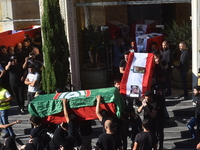 Lebanese clerics pray over the coffins of 16 people, including three Hezbollah militants, who are killed in an Israeli airstrike on the vill...