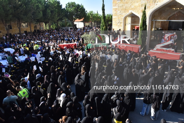 Lebanese clerics pray over the coffins of 16 people, including three Hezbollah militants, who are killed in an Israeli airstrike on the vill...