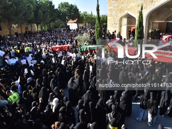 Lebanese clerics pray over the coffins of 16 people, including three Hezbollah militants, who are killed in an Israeli airstrike on the vill...