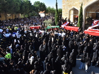 Lebanese clerics pray over the coffins of 16 people, including three Hezbollah militants, who are killed in an Israeli airstrike on the vill...