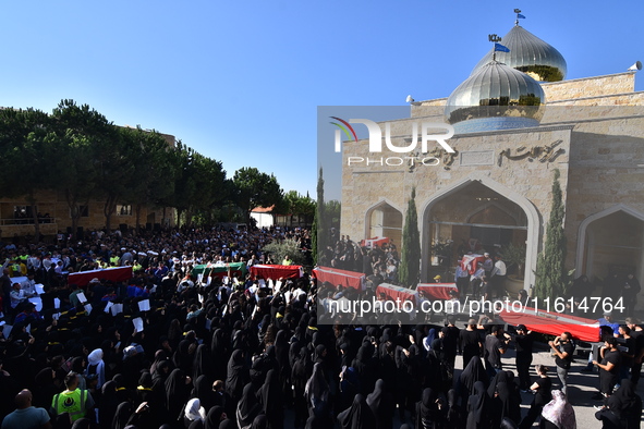 Lebanese clerics pray over the coffins of 16 people, including three Hezbollah militants, who are killed in an Israeli airstrike on the vill...