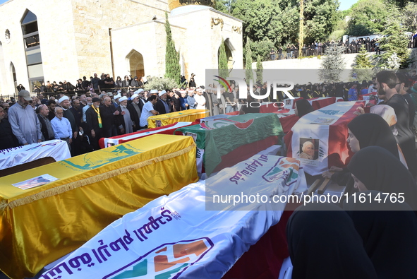 Lebanese clerics pray over the coffins of 16 people, including three Hezbollah militants, who are killed in an Israeli airstrike on the vill...