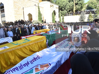 Lebanese clerics pray over the coffins of 16 people, including three Hezbollah militants, who are killed in an Israeli airstrike on the vill...