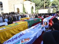 Lebanese clerics pray over the coffins of 16 people, including three Hezbollah militants, who are killed in an Israeli airstrike on the vill...