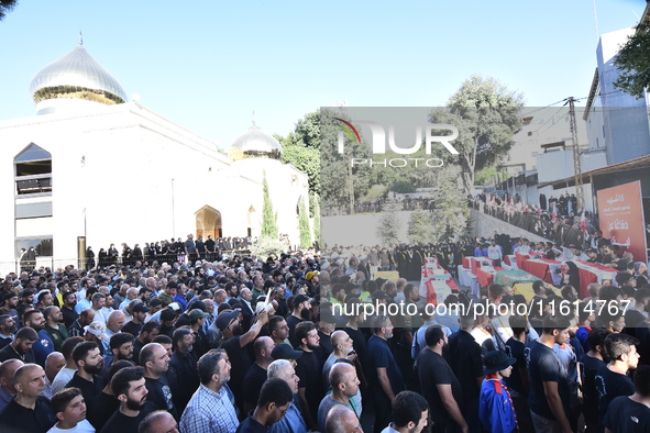 Lebanese clerics pray over the coffins of 16 people, including three Hezbollah militants, who are killed in an Israeli airstrike on the vill...