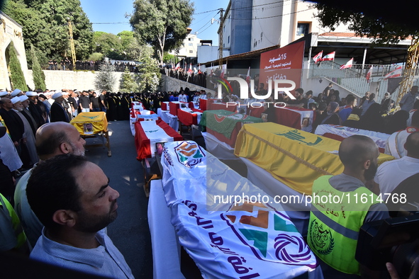 Lebanese clerics pray over the coffins of 16 people, including three Hezbollah militants, who are killed in an Israeli airstrike on the vill...