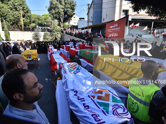 Lebanese clerics pray over the coffins of 16 people, including three Hezbollah militants, who are killed in an Israeli airstrike on the vill...