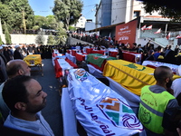 Lebanese clerics pray over the coffins of 16 people, including three Hezbollah militants, who are killed in an Israeli airstrike on the vill...