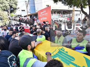 Lebanese clerics pray over the coffins of 16 people, including three Hezbollah militants, who are killed in an Israeli airstrike on the vill...