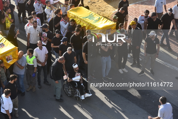 Lebanese clerics pray over the coffins of 16 people, including three Hezbollah militants, who are killed in an Israeli airstrike on the vill...