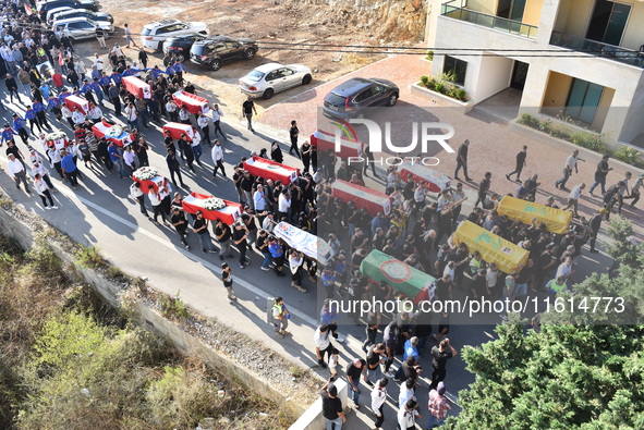 Lebanese clerics pray over the coffins of 16 people, including three Hezbollah militants, who are killed in an Israeli airstrike on the vill...