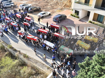 Lebanese clerics pray over the coffins of 16 people, including three Hezbollah militants, who are killed in an Israeli airstrike on the vill...