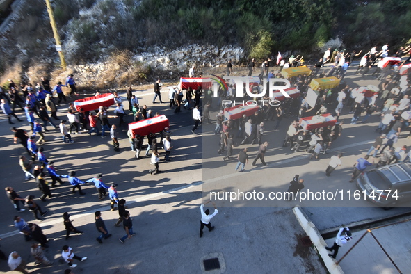 Lebanese clerics pray over the coffins of 16 people, including three Hezbollah militants, who are killed in an Israeli airstrike on the vill...