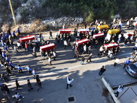 Lebanese clerics pray over the coffins of 16 people, including three Hezbollah militants, who are killed in an Israeli airstrike on the vill...