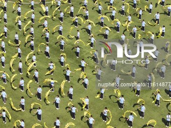 Students dance with a colored ribbon dragon at the No. 2 Middle School of Ecological Cultural Tourism District in Huai'an, China, on Septemb...