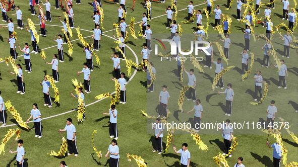 Students dance with a colored ribbon dragon at the No. 2 Middle School of Ecological Cultural Tourism District in Huai'an, China, on Septemb...