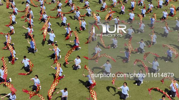 Students dance with a colored ribbon dragon at the No. 2 Middle School of Ecological Cultural Tourism District in Huai'an, China, on Septemb...