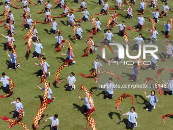 Students dance with a colored ribbon dragon at the No. 2 Middle School of Ecological Cultural Tourism District in Huai'an, China, on Septemb...