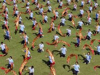 Students dance with a colored ribbon dragon at the No. 2 Middle School of Ecological Cultural Tourism District in Huai'an, China, on Septemb...