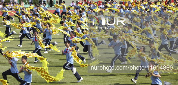 Students dance with a colored ribbon dragon at the No. 2 Middle School of Ecological Cultural Tourism District in Huai'an, China, on Septemb...