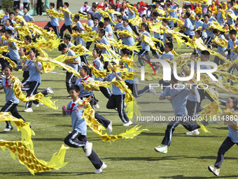 Students dance with a colored ribbon dragon at the No. 2 Middle School of Ecological Cultural Tourism District in Huai'an, China, on Septemb...