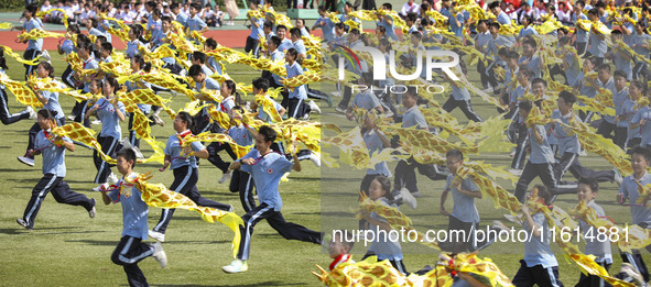 Students dance with a colored ribbon dragon at the No. 2 Middle School of Ecological Cultural Tourism District in Huai'an, China, on Septemb...