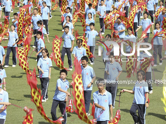 Students dance with a colored ribbon dragon at the No. 2 Middle School of Ecological Cultural Tourism District in Huai'an, China, on Septemb...