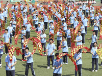 Students dance with a colored ribbon dragon at the No. 2 Middle School of Ecological Cultural Tourism District in Huai'an, China, on Septemb...