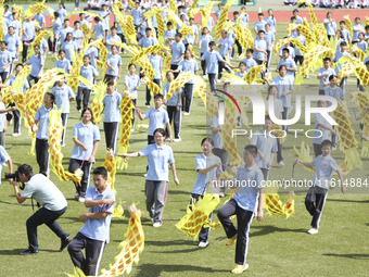 Students dance with a colored ribbon dragon at the No. 2 Middle School of Ecological Cultural Tourism District in Huai'an, China, on Septemb...