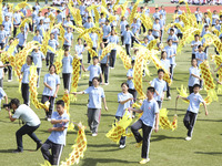 Students dance with a colored ribbon dragon at the No. 2 Middle School of Ecological Cultural Tourism District in Huai'an, China, on Septemb...