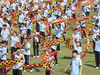 Students dance with a colored ribbon dragon at the No. 2 Middle School of Ecological Cultural Tourism District in Huai'an, China, on Septemb...