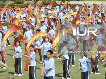 Students dance with a colored ribbon dragon at the No. 2 Middle School of Ecological Cultural Tourism District in Huai'an, China, on Septemb...