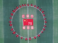 Students pose for a photo with the national flag at the Jindu Huating campus of Xiaoyaojin Primary School in Hefei, China, on September 27,...