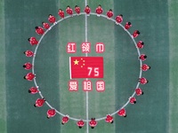 Students pose for a photo with the national flag at the Jindu Huating campus of Xiaoyaojin Primary School in Hefei, China, on September 27,...