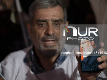 An Iranian protester holds his cellphone featuring a portrait of Lebanon's Hezbollah Secretary General, Hassan Nasrallah, during a protest g...