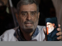 An Iranian protester holds his cellphone featuring a portrait of Lebanon's Hezbollah Secretary General, Hassan Nasrallah, during a protest g...