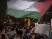 An Iranian protester waves a Palestinian flag while taking part in a protest gathering to condemn an Israeli air strike against Lebanon, in...