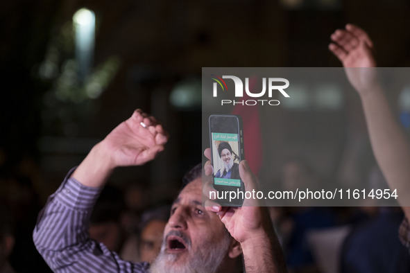 An Iranian protester holds his cellphone featuring a portrait of Lebanon's Hezbollah Secretary General, Hassan Nasrallah, during a protest g...