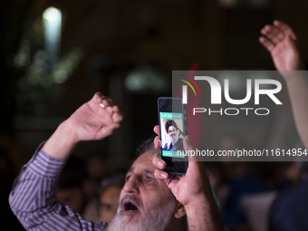 An Iranian protester holds his cellphone featuring a portrait of Lebanon's Hezbollah Secretary General, Hassan Nasrallah, during a protest g...